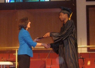 Graduate Steven Turner recieves his diploma from Board Chair Cindy Skinner